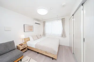 a small bedroom with a bed and a couch at \u30eb\u30eb\u30df\u30a8\u30fc\u30eb\u4e21\u56fd in Tokyo