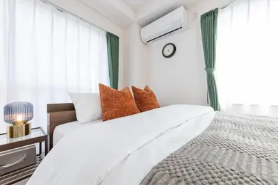 a white bedroom with a bed and a window at Bell tree Higashi-Mukojima in Tokyo
