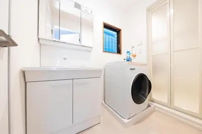 a white laundry room with a washing machine at Bell tree Higashi-Mukojima in Tokyo