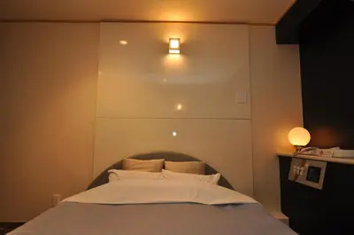 a bedroom with a bed with a light above it at Hotel Boston Club (Adult Only) in Tokyo