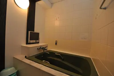 a bath tub in a bathroom with a tv on the wall at Hotel Boston Club (Adult Only) in Tokyo
