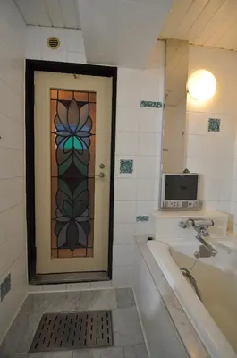 a bathroom with a door with a sink and a tub at Hotel Boston Club (Adult Only) in Tokyo