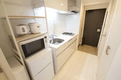 a small kitchen with a sink and a microwave at \u9ebb\u5e03\u5341\u756a\u99c5\u5f92\u6b695\u5206 in Tokyo