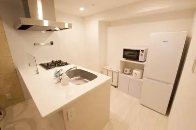 a white kitchen with a sink and a microwave at \u9ebb\u5e03\u5341\u756a\u99c5\u5f92\u6b695\u5206 in Tokyo