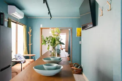 a room with a table with bowls and a vase of flowers at Tokyo Manga Stay \u99c51\u5206\u8cb8\u5207\u306785\u5e73\u7c73 \u65e5\u672c\u306e\u6709\u540d\u30de\u30f3\u30ac\u304c\u8aad\u3081\u308b\u5bbf 9\u540d\u307e\u3067OK in Tokyo