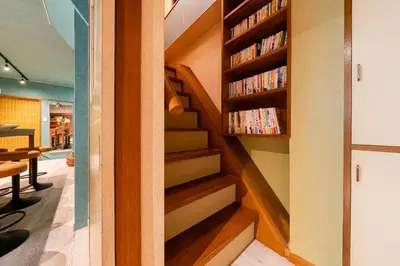 a book shelf filled with books in a room at Tokyo Manga Stay \u99c51\u5206\u8cb8\u5207\u306785\u5e73\u7c73 \u65e5\u672c\u306e\u6709\u540d\u30de\u30f3\u30ac\u304c\u8aad\u3081\u308b\u5bbf 9\u540d\u307e\u3067OK in Tokyo