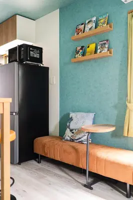 a room with a couch and a table and a refrigerator at Tokyo Manga Stay \u99c51\u5206\u8cb8\u5207\u306785\u5e73\u7c73 \u65e5\u672c\u306e\u6709\u540d\u30de\u30f3\u30ac\u304c\u8aad\u3081\u308b\u5bbf 9\u540d\u307e\u3067OK in Tokyo