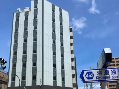 a tall white building with a sign in front of it at Hotel LiVEMAX Ryogoku in Tokyo