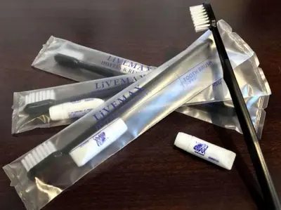 two toothbrushes and a toothbrush wrapper on a table at Hotel LiVEMAX Ryogoku in Tokyo