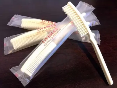 a toothbrush and two toothpaste packets on a table at Hotel LiVEMAX Ryogoku in Tokyo