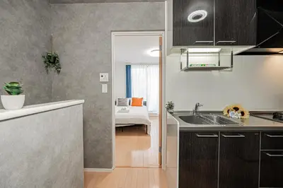 a kitchen with a sink and a room with a bed at 301 6 mins walk from Higashi-Jujo Station Comfortable 1 bedroom apartment on the 3rd floor Direct access to Akihabara and Ueno in Tokyo