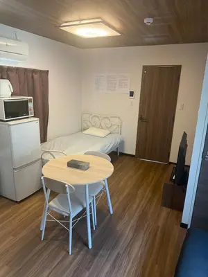 a small room with a table and a bed at \u677e\u5c4b\u30db\u30c6\u30eb5\u968e in Tokyo