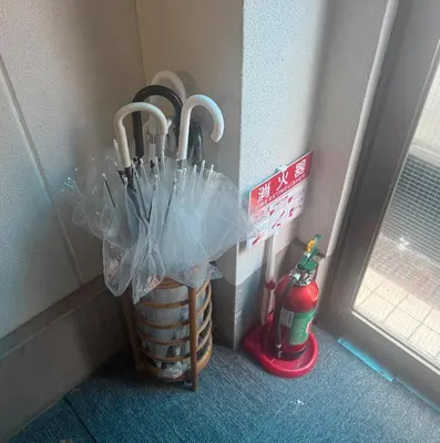 a basket of umbrellas sitting next to a wall at \u677e\u5c4b\u30db\u30c6\u30eb5\u968e in Tokyo