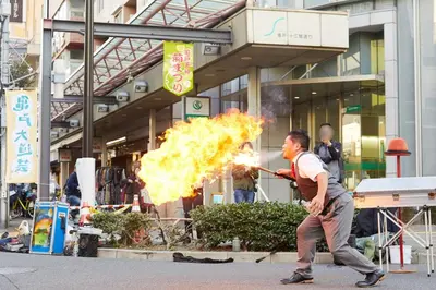 a man is running with a fire in front of a building at \u677e\u5c4b\u30db\u30c6\u30eb5\u968e in Tokyo