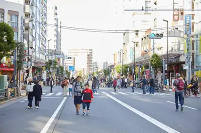 a group of people walking down a busy city street at \u677e\u5c4b\u30db\u30c6\u30eb5\u968e in Tokyo