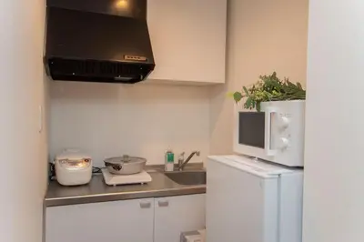 a small kitchen with a sink and a microwave at c4F \u6d45\u8349 \u4e0a\u91ce\u5546\u5708\u590f\u7f8e\u30db\u30c6\u30eb \u9ad8\u7ea7\u72ec\u680b\u522b\u5885 \u72ec\u7acb\u536b\u6d74 \u8f66\u7ad9\u6b65\u884c\u4e94\u5206\u949f \u6210\u7530\u7fbd\u7530\u4e00\u7ebf\u76f4\u901a in Wada