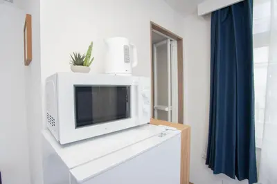 a microwave sitting on top of a cabinet in a room at c4F \u6d45\u8349 \u4e0a\u91ce\u5546\u5708\u590f\u7f8e\u30db\u30c6\u30eb \u9ad8\u7ea7\u72ec\u680b\u522b\u5885 \u72ec\u7acb\u536b\u6d74 \u8f66\u7ad9\u6b65\u884c\u4e94\u5206\u949f \u6210\u7530\u7fbd\u7530\u4e00\u7ebf\u76f4\u901a in Wada