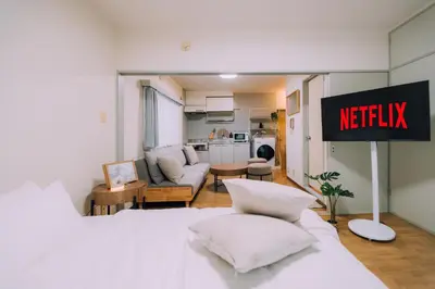 a hotel room with a bed and a netflix sign at Showa Bloom Near Shinjuku Station in Tokyo