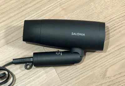 a black flashlight sitting on a wooden table at Shinkoiwa HOUSE in Tokyo