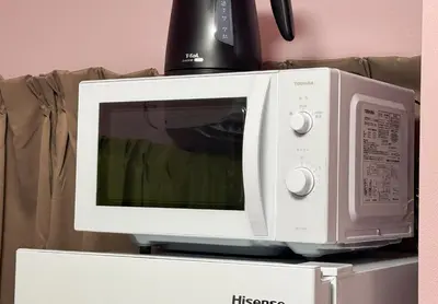a microwave oven sitting on top of a refrigerator at Shinkoiwa HOUSE in Tokyo