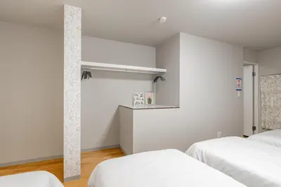 two beds in a room with white walls at Shinkoiwa HOUSE in Tokyo
