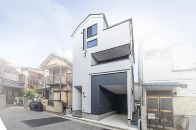 a white house with a garage on a street at 7min Walk from Station 100sqm Max 10 Direct to Skytree Haneda Narita New Built in Tokyo