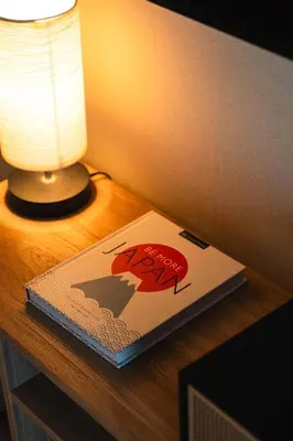 a book sitting on a table next to a lamp at Shinjuku Zen House 2F 70sqm Traditional Reno Premium Bed R2 in Tokyo