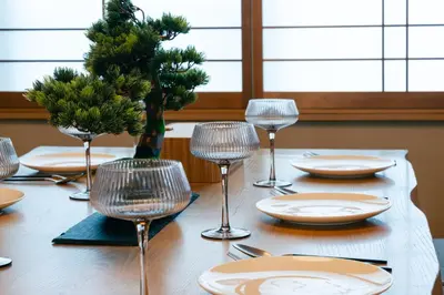 a table with chairs and plates and wine glasses at Shinjuku Zen House 2F 70sqm Traditional Reno Premium Bed R2 in Tokyo