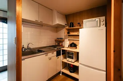 a kitchen with white appliances and a white refrigerator at Shinjuku Zen House 2F 70sqm Traditional Reno Premium Bed R2 in Tokyo