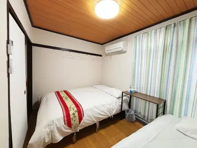 a small bedroom with two beds and a window at HANANOSATO\u677f\u6a4b\u4e2d\u4e38\u753aa in Tokyo