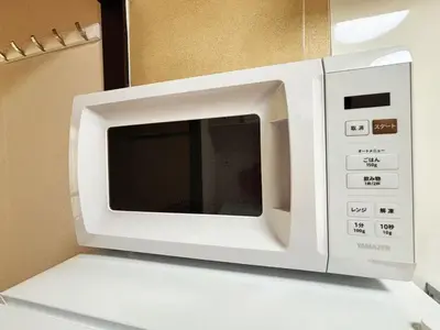 a white microwave oven sitting on top of a counter at HANANOSATO\u677f\u6a4b\u4e2d\u4e38\u753aa in Tokyo