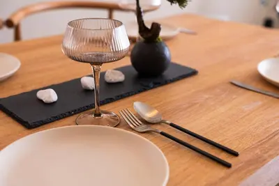a wooden table with a plate and a wine glass at Shinjuku 90sqm Private Villa with Sakura View Spacious & Quiet in Tokyo