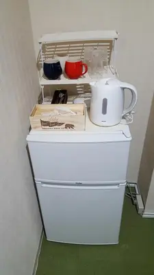 a white refrigerator with dishes and a tea pot on top at Space Air Building 5F - Vacation STAY 11431 in Tokyo