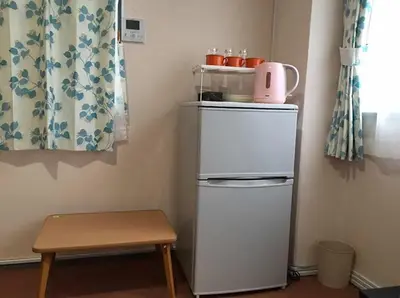a small white refrigerator in a room with a table at Space Air Building 5F - Vacation STAY 11430 in Tokyo