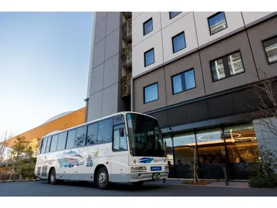 a white bus parked in front of a building at Far East Village Hotel Tokyo Ariake - Vacation STAY 31697v in Tokyo