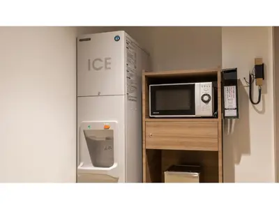 a small kitchen with a microwave and a refrigerator at Far East Village Hotel Tokyo Ariake - Vacation STAY 31648v in Tokyo