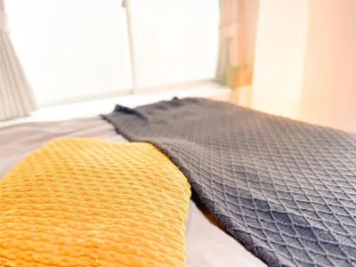 a yellow and gray pillow on a bed with a window at Katsushika-ku - House - Vacation STAY 20111 in Tokyo
