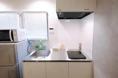 a kitchen with a sink and a microwave and a refrigerator at Belshaart Kamikitazawa - Vacation STAY 20141 in Tokyo