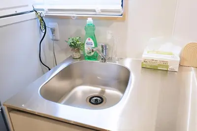 a kitchen sink with a green detergent bottle on it at Belshaart Kamikitazawa - Vacation STAY 20141 in Tokyo