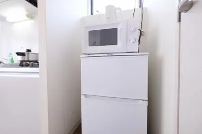 a microwave on top of a refrigerator in a kitchen at Belshaart Kamikitazawa - Vacation STAY 20138 in Tokyo
