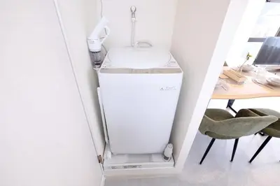a laundry room with a sink and a washer and dryer at Belshaart Kamikitazawa - Vacation STAY 20138 in Tokyo