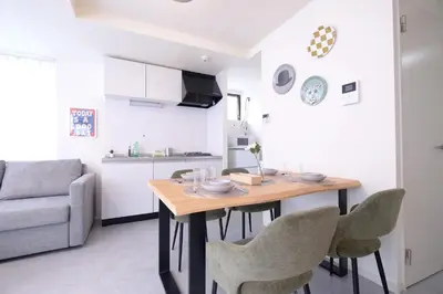 a kitchen and living room with a wooden table and chairs at Belshaart Kamikitazawa - Vacation STAY 20138 in Tokyo