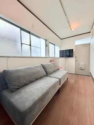 a large gray couch in a room with windows at Terrace Tokyo Sugamo in Tokyo