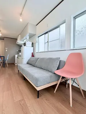 a living room with a couch and a pink chair at Terrace Tokyo Sugamo in Tokyo