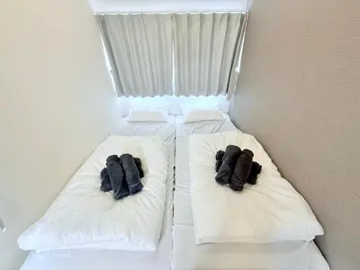 two beds in a room with towels on them at Terrace Tokyo Sugamo in Tokyo