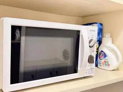 a white microwave oven sitting on a shelf at Ikebukuro Sugamo\u99c5\u8fd1B4 in Tokyo