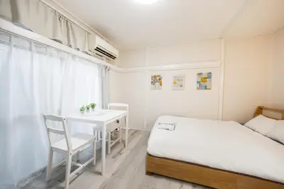 a small bedroom with a bed and a table at 7 min to JR Otsuka,Direct Yamanote Line ,1 stop to Ikebukuro,Direct to Shinjuku ,Shibuya,Fully Renovated,18 sqm,2 Guests #102 in Tokyo