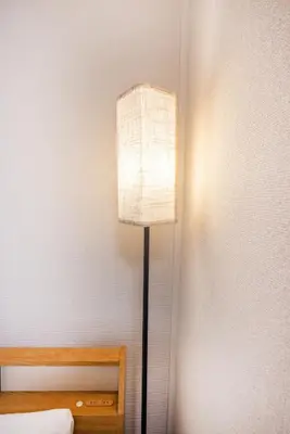 a lamp in the corner of a room next to a bed at 7 min to JR Otsuka,Direct Yamanote Line ,1 stop to Ikebukuro,Direct to Shinjuku ,Shibuya,Fully Renovated,18 sqm,2 Guests #102 in Tokyo