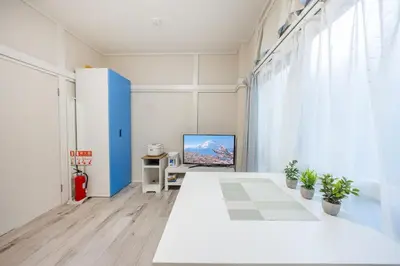 a room with a white table and a tv at 7 min to JR Otsuka,Direct Yamanote Line ,1 stop to Ikebukuro,Direct to Shinjuku ,Shibuya,Fully Renovated,18 sqm,2 Guests #102 in Tokyo