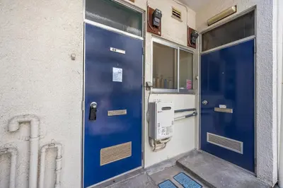 a blue door on the side of a building at 7 min to JR Otsuka,Direct Yamanote Line ,1 stop to Ikebukuro,Direct to Shinjuku ,Shibuya,Fully Renovated,18 sqm,2 Guests #102 in Tokyo